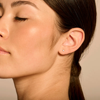 Bicolor gouden oorknop met kleine natuurlijke diamant in 14k geel en wit goud.