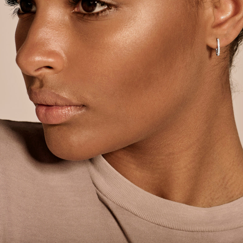 Kleine oorringen van 14k wit goud met fonkelende diamanten detail.