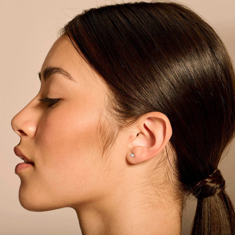 14k wit goud oorknop met kleine fonkelende diamant in zijprofiel.