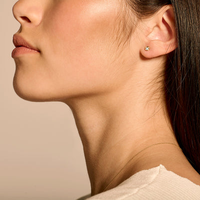 14k geel gouden oorknop met fonkelende natuurlijke diamant, close-up oorzijde.