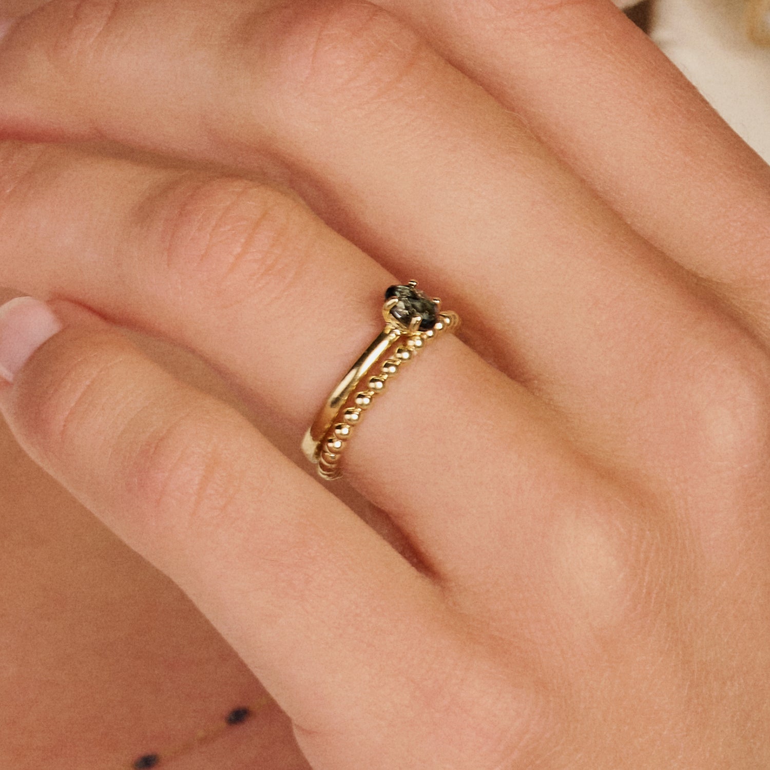 14k geelgouden bolletjes ring en ring met Swiss blue topaas, samen gestyled.
