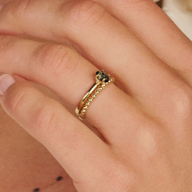 14k geelgouden bolletjes ring en ring met Swiss blue topaas, samen gestyled.