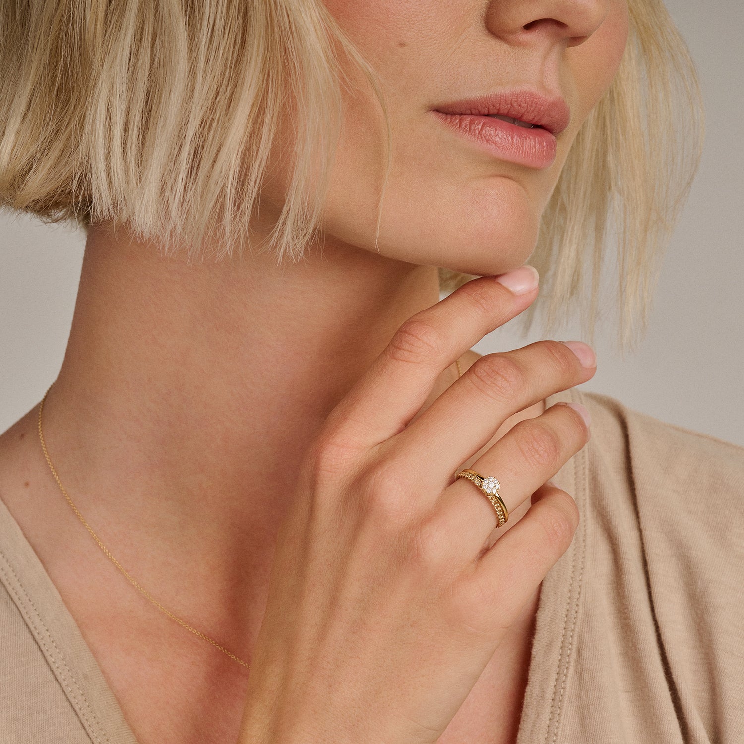 14k geelgouden ring met zirkonia cirkel en ring met schakelmotief, samen gestyled.