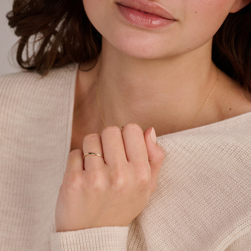 A genuine 14ct yellow gold delicate stacking ring, worn on the finger.