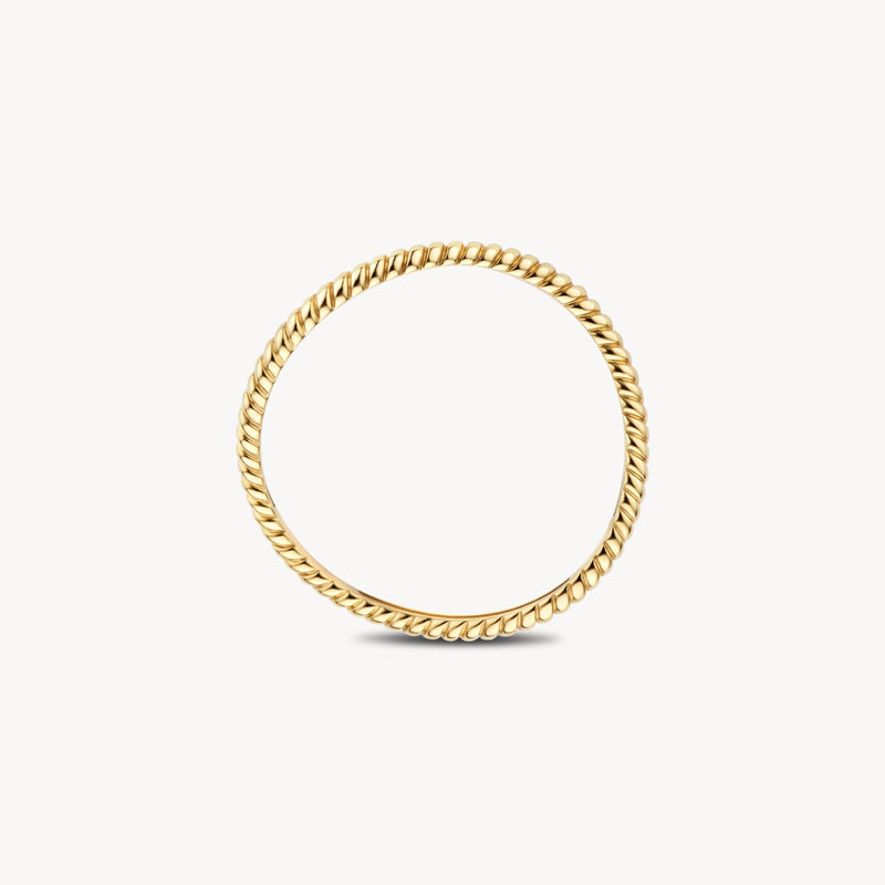 Une bague empilable intemporelle en or jaune 14 carats, portée au doigt.