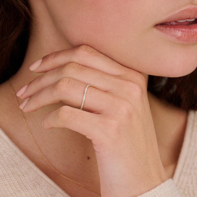 Bague en or jaune 14 carats Bague sertie de Zircone clairs, portée au doigt.