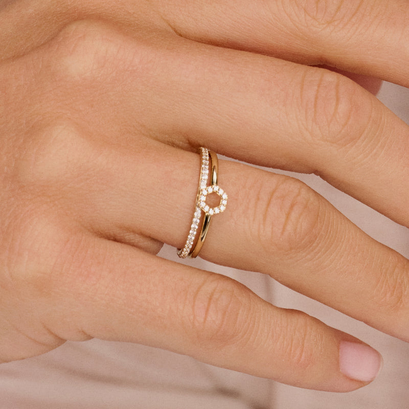 Bague en or jaune 14 carats avec des Zircone en pente, porté au doigt.