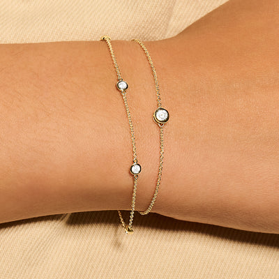 Delicate 14k goud armband met drie ronde zirkonia in gladomzetting op fijne schakelketting.