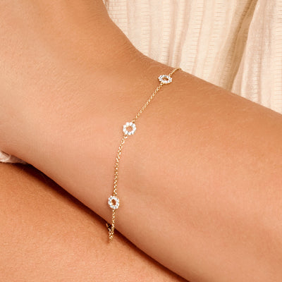 Delicate 14k goud armband met schakels en cirkelvormige zirkonia details.