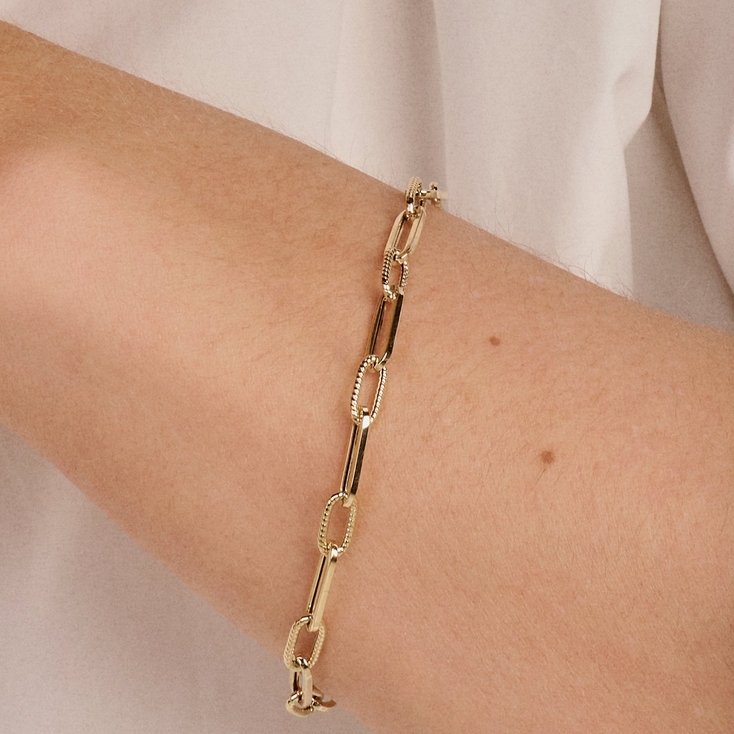14k goud armband met grove schakels en koordmotief, elegant en minimalistisch.