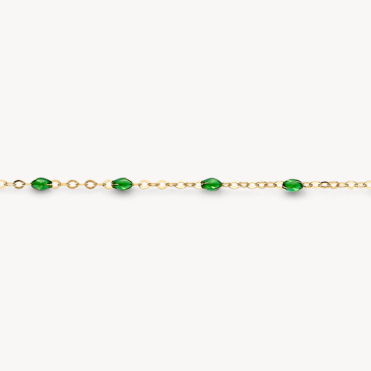 Armband met fijne schakels in 14k goud en groene resin kralen verdeeld over de lengte.