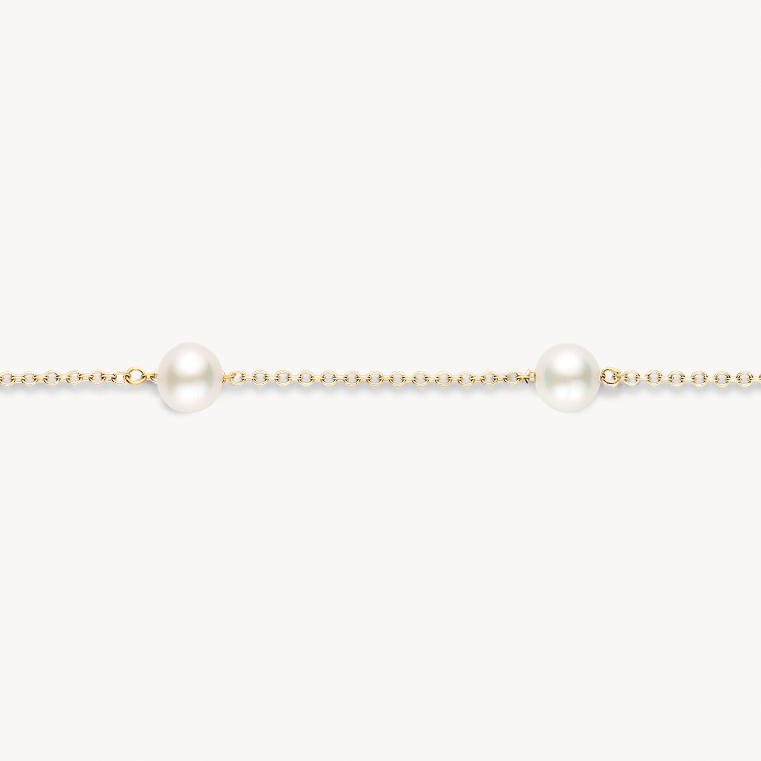 Bracelet à maillons en or jaune 14 carats avec un Perle blanc rond, gros plan.