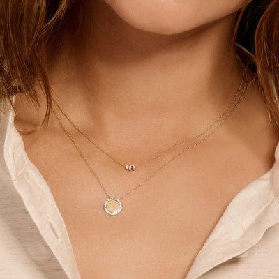 Delicate 14k goud ketting met drie kleine ringetjes en zirkonia aan fijne ketting.