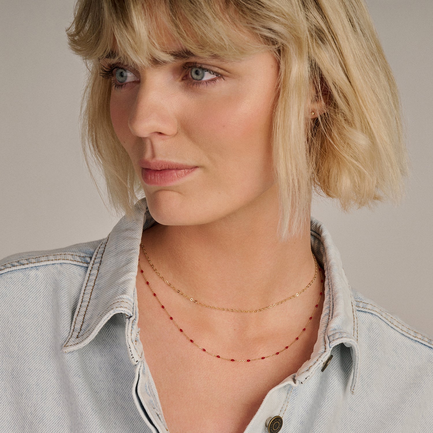 Fijn 14k goud kettinkje met kleine schakels gedragen met roodachtige kralen ketting.