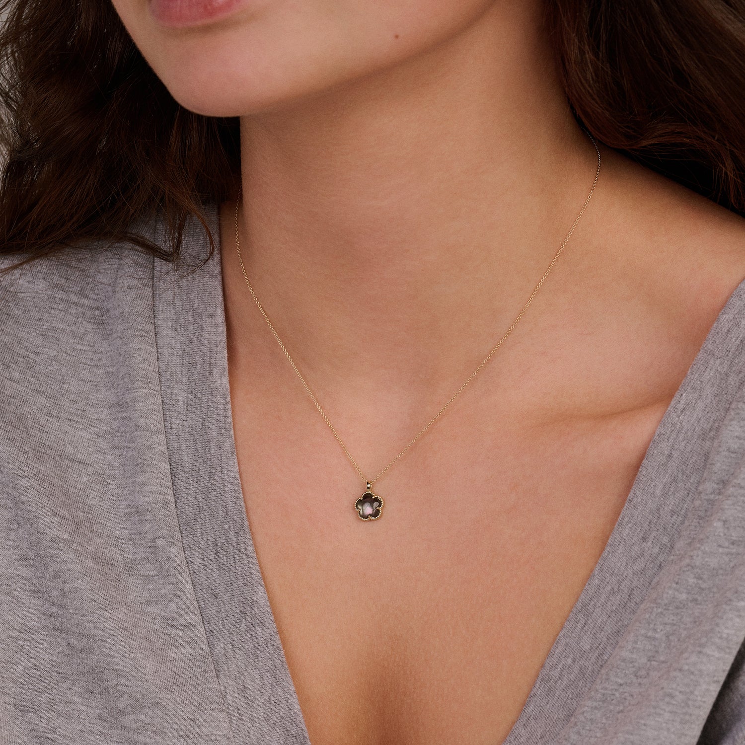 Collier en or jaune 14 carats avec un pendentif Nacre, porté autour du cou.