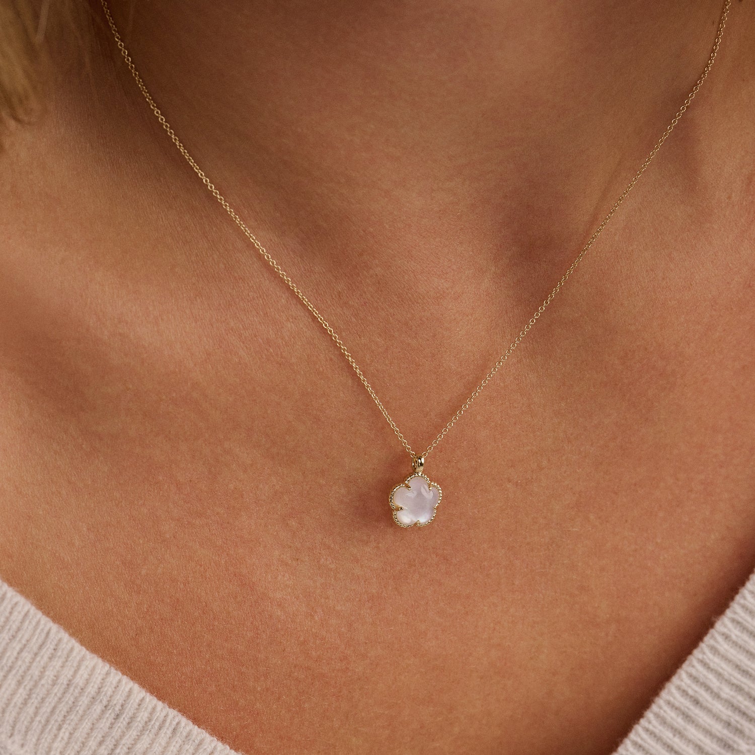 Collier en or jaune 14 carats avec un pendentif Nacre, porté autour du cou.