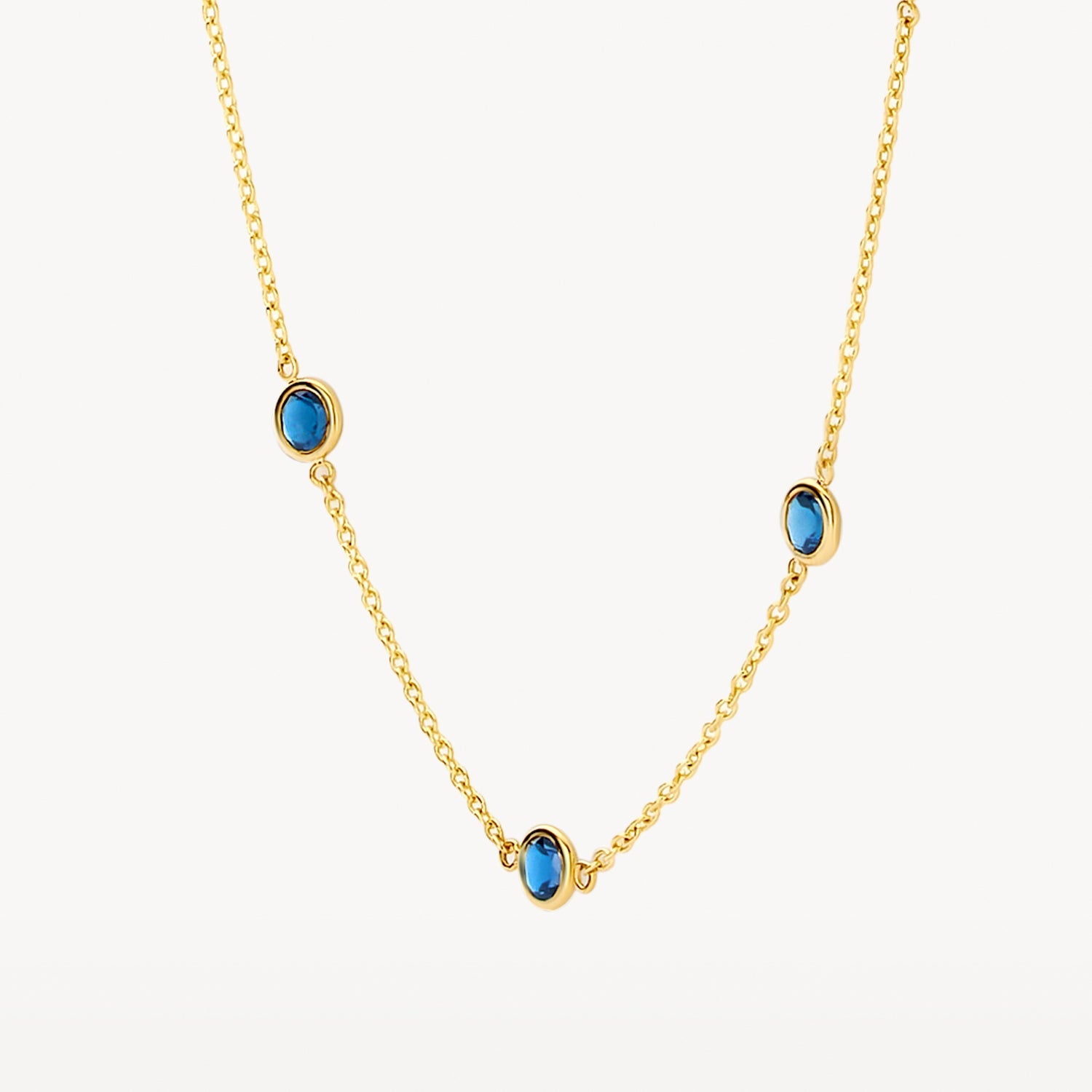 Collier en or jaune 14 carats serti d'une topaze « London Blue » bleue, gros plan.