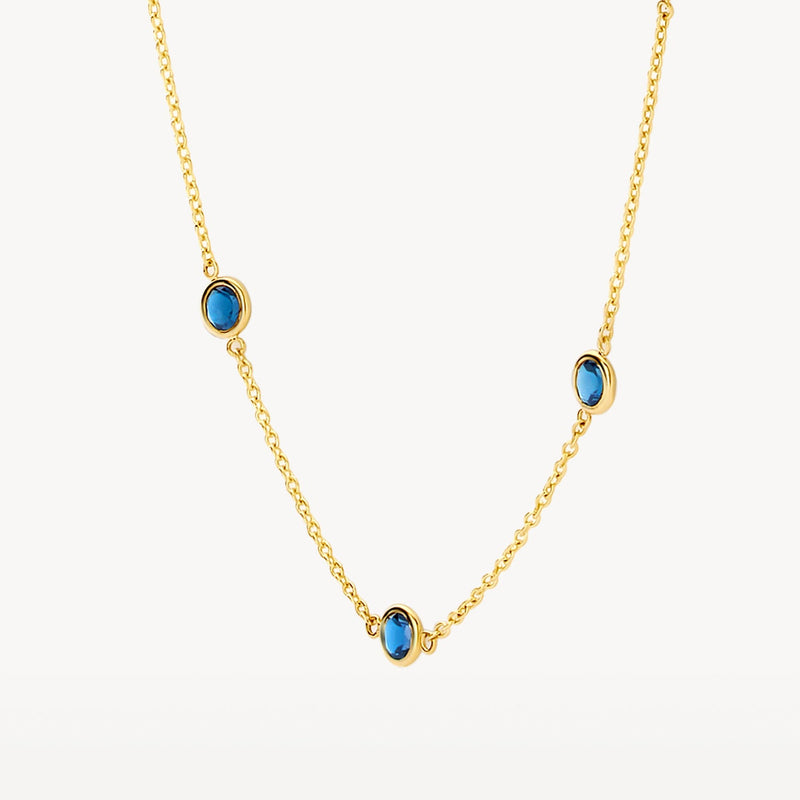Collier en or jaune 14 carats serti d'une topaze « London Blue » bleue, gros plan.