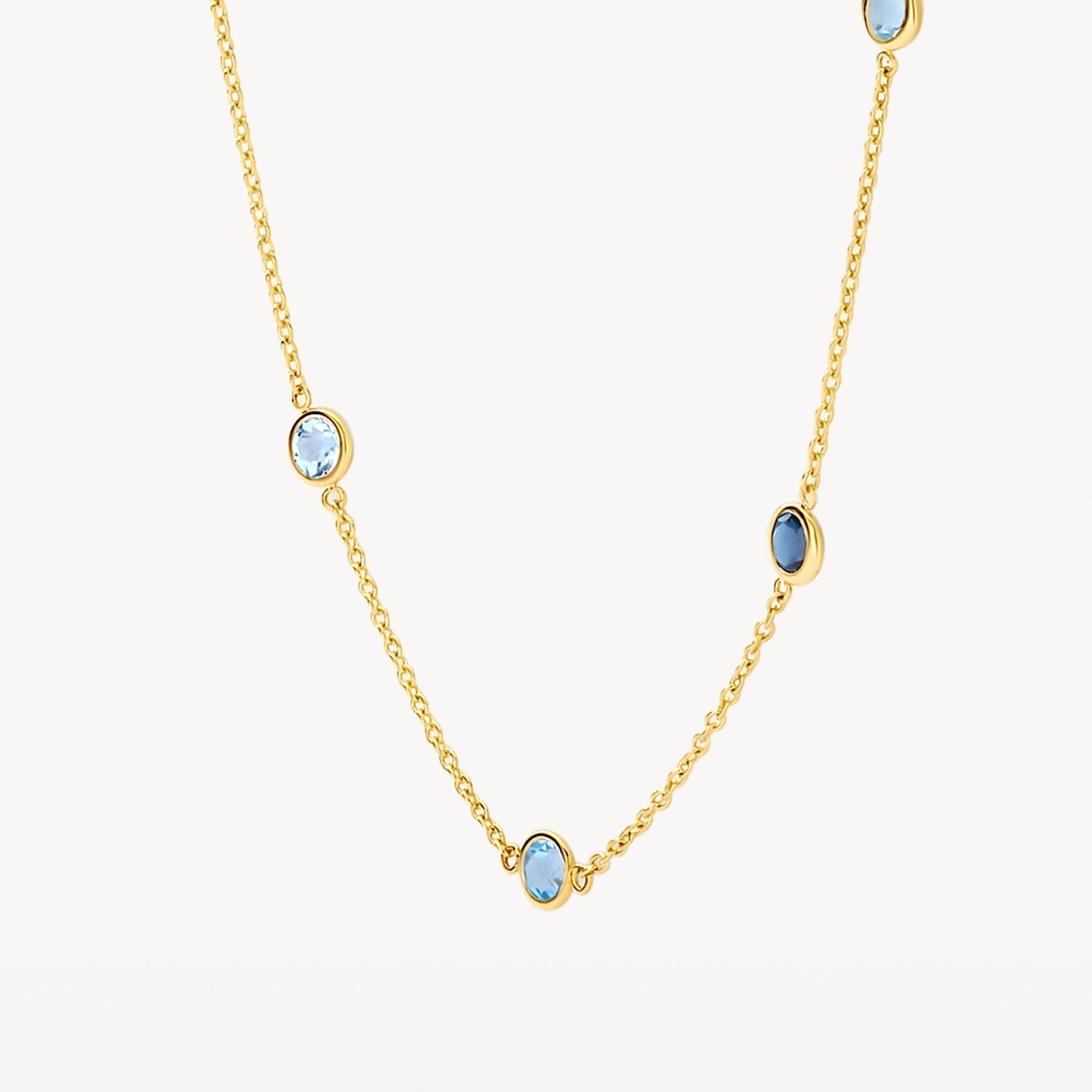 Collier en or jaune 14 carats avec une topaze bleu ciel, gros plan.