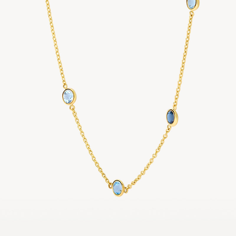 Collier en or jaune 14 carats avec une topaze bleu ciel, gros plan.