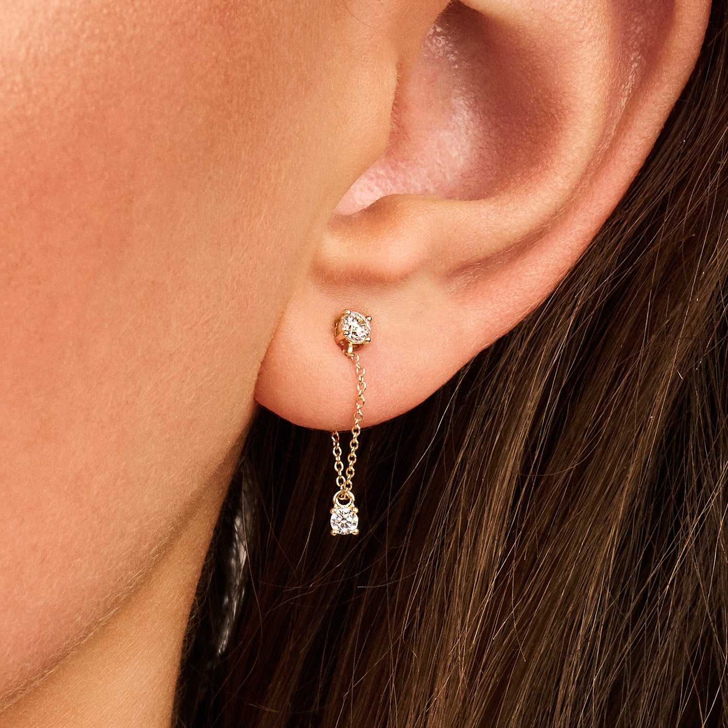 Puces d’oreilles deux zircones reliées par une fine chaîne or 14 carats