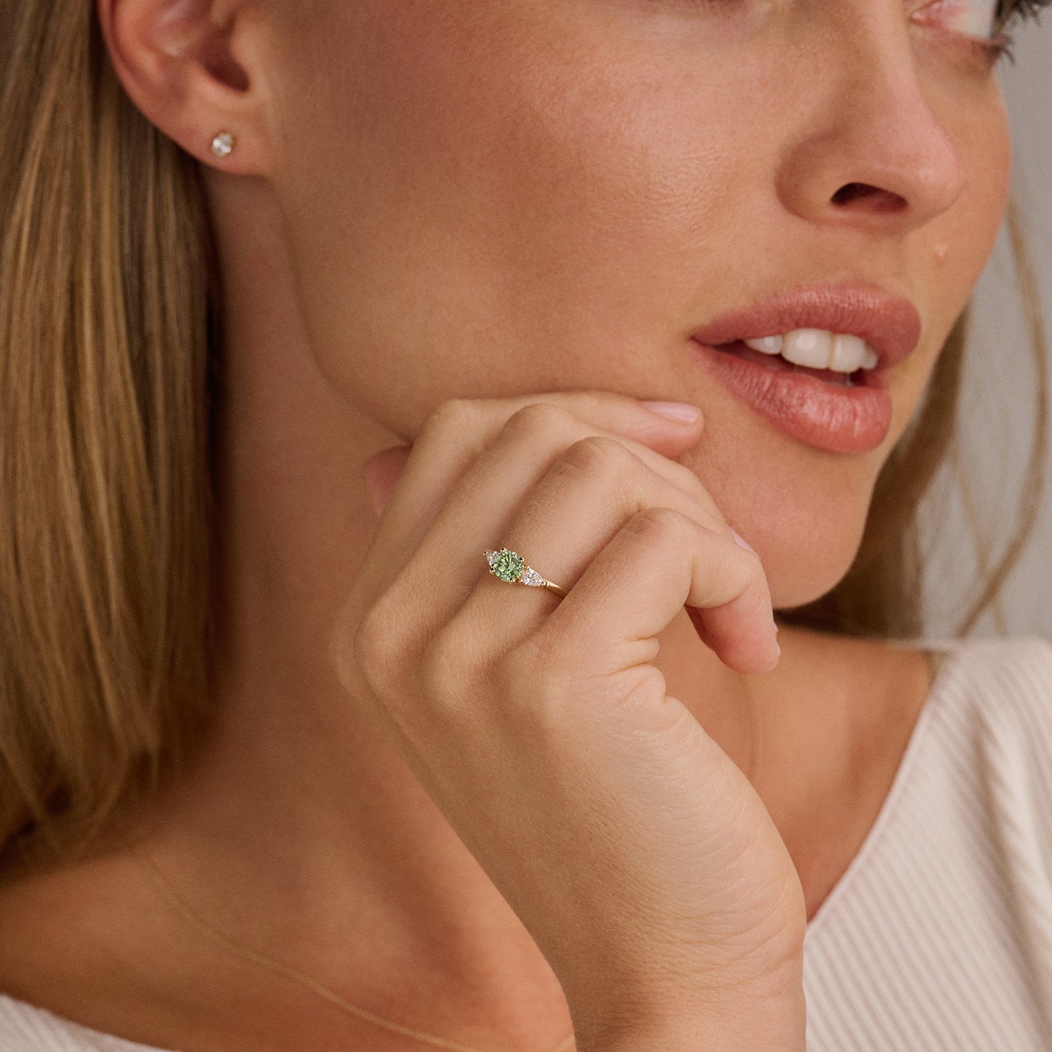14ct yellow gold ring with Lab Grown Diamond and green Diamond, worn on the finger.