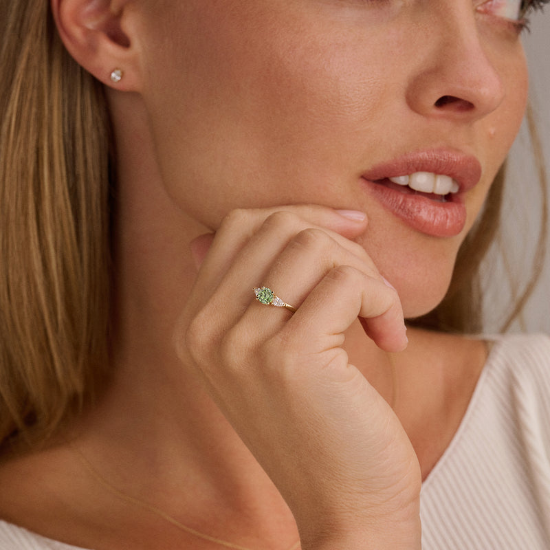 14ct yellow gold ring with Lab Grown Diamond and green Diamond, worn on the finger.