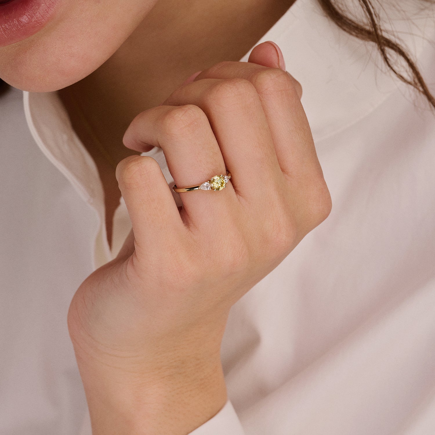 Bague en or jaune 14 carats Bague sertie de Diamant de synthèse et d'un diamant jaune, portée au doigt.