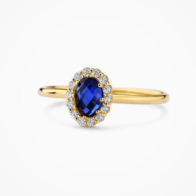 14k geel- en witgouden ring met lab grown en blauwe diamant, close-up.